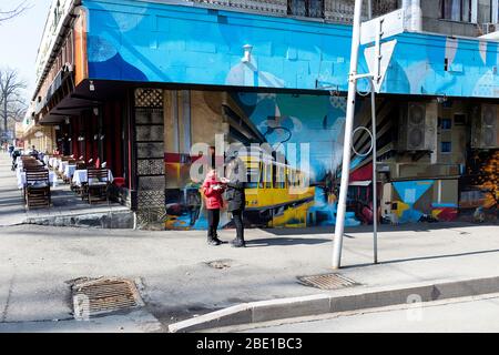 Scena di strada in Almaty, madre e figlio in piedi all'angolo di una strada, di fronte e tenendo spuntini, Kazakistan Foto Stock