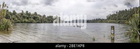 LAGO MAPOURIKA, NUOVA ZELANDA - Novembre 17 2019: Paesaggio con le rive verdi e scivolamento sul lago, girato in luce nuvolosa primavera brillante il 17 201 novembre Foto Stock