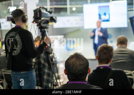 Pubblico ascolta docente al seminario Foto Stock