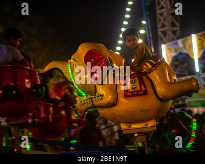 Mumbai, India - 01 dicembre 2019: I bambini indiani che si godono giostra in elefante al parco divertimenti Foto Stock