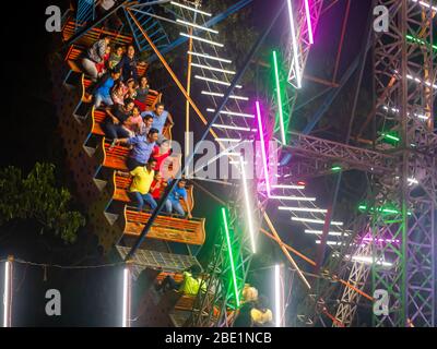 Mumbai, India - 01 dicembre 2019: La famiglia indiana si diverta al parco divertimenti illuminato di notte Foto Stock