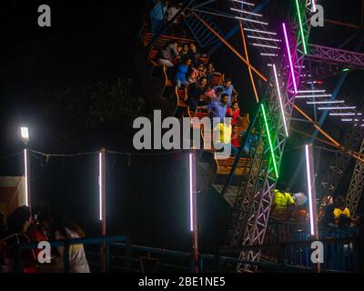 Mumbai, India - 01 dicembre 2019: La famiglia indiana si diverta al parco divertimenti illuminato di notte Foto Stock