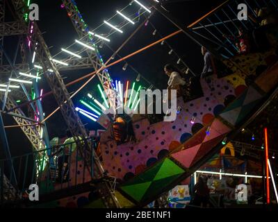 Mumbai, India - 01 dicembre 2019: La famiglia indiana si diverta al parco divertimenti illuminato di notte Foto Stock