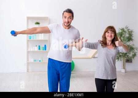 Donna che fa esercizi sportivi con allenatore personale Foto Stock