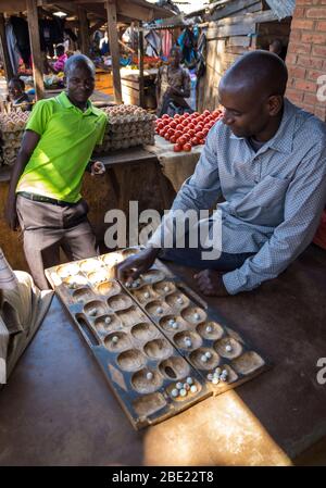 Uomini che giocano il tradizionale gioco di Bao nel mercato di Mzuzu, Malawi Foto Stock