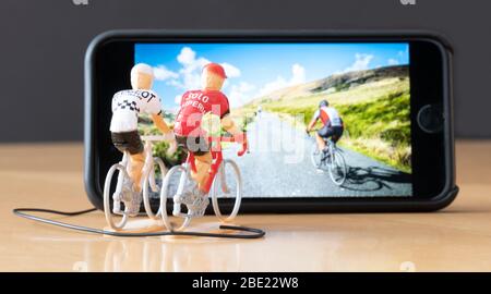 Mini ciclisti figure indoor training con l'aiuto di un iPhone. Foto Stock