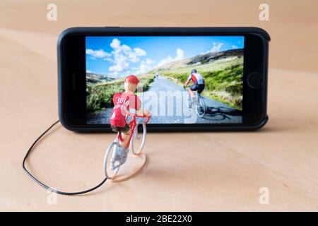 Mini ciclisti figure indoor training con l'aiuto di un iPhone. Foto Stock