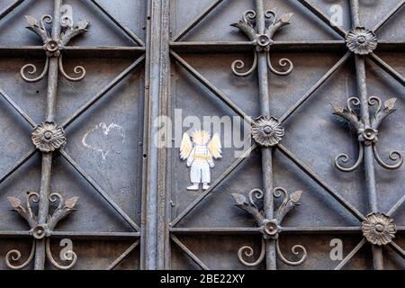 Piccolo angelo di carta e cuore di gesso su cancello decorativo in ferro battuto in metallo a Mitte, Berlino. Angelo custode Foto Stock