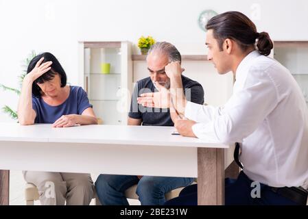 Il consulente finanziario dando consigli di pensionamento alla vecchia coppia Foto Stock