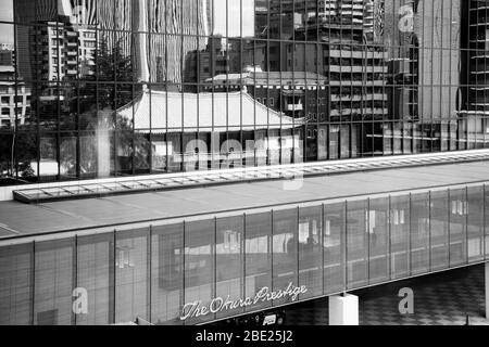 Un edificio tradizionale con un tetto di tegole verdi si riflette nella facciata in vetro dell'Okura Prestige Tower all'Okura Tokyo, nel quartiere di Minato, Giappone, circondato da grattacieli. Foto Stock