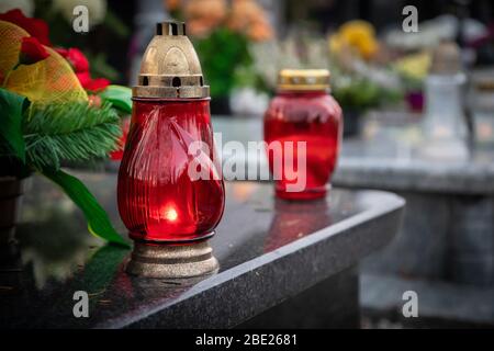 Wroclaw, Polonia - 02 novembre 2019: Candele rosse sulla tomba dedicata alla Giornata dei ANIME - festa cristiana della memoria per le anime di coloro che ha Foto Stock