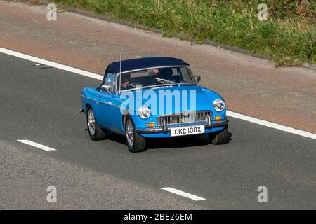 1982 80s blu MG B convertibile; veicoli in movimento per il traffico veicolare, veicolo di guida su strade del Regno Unito, auto classiche, amati, veterano, vecchio timer, restaurato, da collezione, motori, vintage, patrimonio, Vecchi motori conservati, a motore sulla autostrada M6 Foto Stock