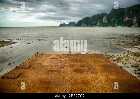 Arrugginito molo di mare di fronte alla baia. Foto Stock