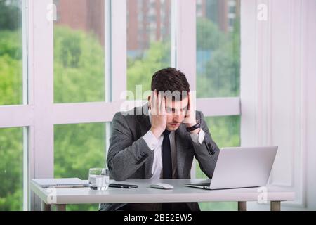 Il giovane uomo d'affari riceve notizie difettose in ufficio Foto Stock