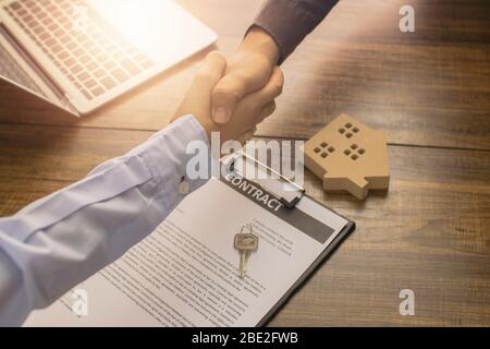 Primo piano mano scuotere e immobiliare sul tavolo Foto Stock