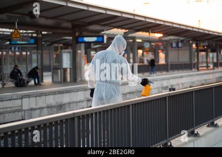 Un uomo disinfetta gli spazi pubblici al momento della crisi della corona Foto Stock