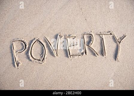 Semplice messaggio di povertà scritto a mano all'aperto sulla spiaggia di sabbia liscia Foto Stock