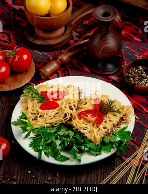 spaghetti con carne ripiena in salsa e pomodori con erbe Foto Stock