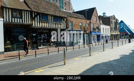 Watford, Regno Unito. 11 aprile 2020. Un uomo cammina lungo una strada vuota nel centro commerciale di Watford il sabato di Pasqua durante il blocco, mentre la pandemia del coronavirus (COVID19) continua. Credit: Stephen Chung / Alamy Live News Foto Stock