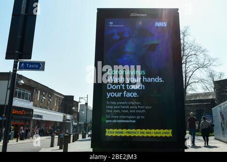 Watford, Regno Unito. 11 aprile 2020. Uno schermo pubblicitario digitale promuove un messaggio nel centro commerciale di Watford il sabato di Pasqua durante il blocco, mentre la pandemia del coronavirus (COVID19) continua. La schermata fornisce istruzioni sulla protezione contro il virus. Credit: Stephen Chung / Alamy Live News Foto Stock