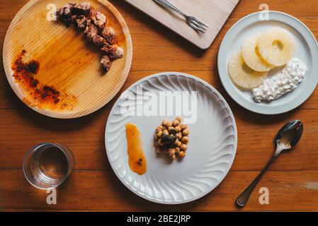 Tipico pasto galiziano di tre piatti, con polpo, ceci e ananas Foto Stock
