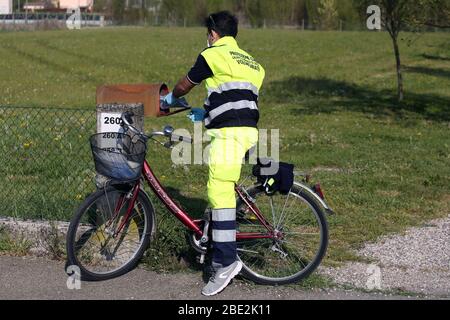 Modena, Italia. 11 aprile 2020. Cavezzo (Mo). I volontari della protezione civile sulle biciclette distribuiscono a porta le maschere necessarie per contenere la diffusione del Coronavirus (ROBERTO BRANCOLINI/Fotogramma, Modena - 2020-04-11) p.s. la foto e' utilizzabile nel ripetto del contenuto in cui e' stata battuta, e senza intenzione diffamatorio del presente delle persone rapate Credit: Independent Photo Agency Srl/Alamy Live News Foto Stock