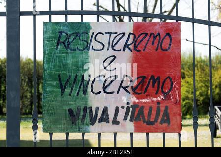 Modena, Italia. 11 aprile 2020. Cavezzo (Mo). Un cartellone con incitamento a battere il Coronavirus appeso fuori da un cancello (ROBERTO BRANCOLINI/Fotogramma, Modena - 2020-04-11) p.s. la foto e' utilizzabile nel ripetto del contatto in cui e' stata battuta, e senza intenzione diffamatorio del decoro delle persone presentate Credit: Agenzia fotografica indipendente Live News/News Foto Stock