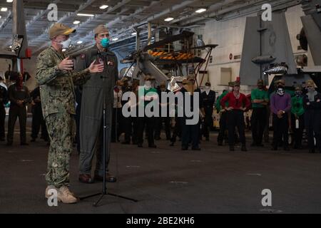 Porto di Apra, Guam. 11 Aprile 2020. I marinai della Marina degli Stati Uniti assegnati alla portaerei USS Theodore Roosevelt (CVN 71) e imbarcati lo staff ascoltano come Vice ADM. William Merz, centro, comandante, U.S. 7th Fleet, risponde alle domande durante una visita alla nave il 7 aprile 2020. Merz è arrivato a Guam per assaggi e sostenere gli sforzi di recupero COVID-19 in corso per l'equipaggio di Theodore Roosevelt. Theodore Roosevelt si trova a Guam per una visita al porto programmata per il rifornimento e il riposo dell'equipaggio durante il loro spiegamento programmato nell'Indo-Pacific. Foto di MC1 Kaylianna Genier/U.S. Navy/UPI Credit: Notizie live UPI/Alamy Foto Stock