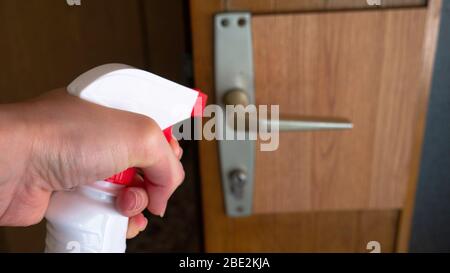 Pulizia delle maniglie delle porte con un antisettico durante un'epidemia. Foto Stock