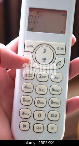 Telefono cordless in mano. Numero di emergenza 911 Foto Stock