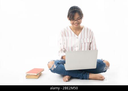 Ragazza giovane seduto e utilizzando il laptop isolato su sfondo bianco Foto Stock