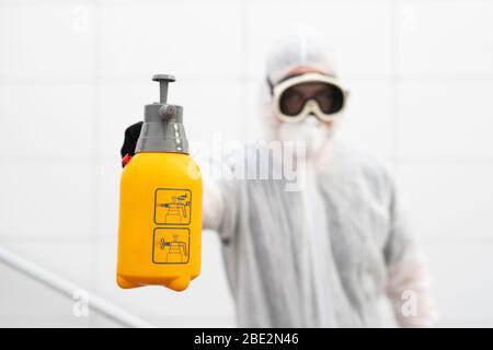 Un uomo disinfetta gli spazi pubblici al momento della crisi della corona Foto Stock