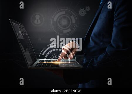 Primo piano mano di businessman stampa su laptop e utilizzando l'interfaccia moderna pagamenti online shopping, tecnologia di marketing digitale e innovazione finanziaria Foto Stock