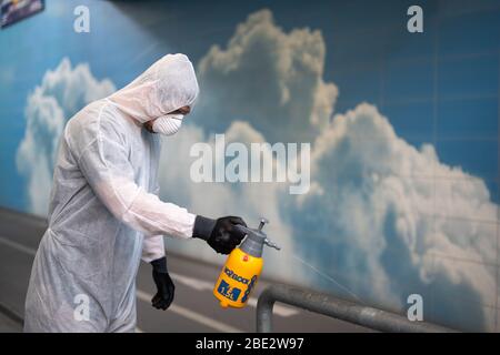 Un uomo disinfetta gli spazi pubblici al momento della crisi della corona Foto Stock