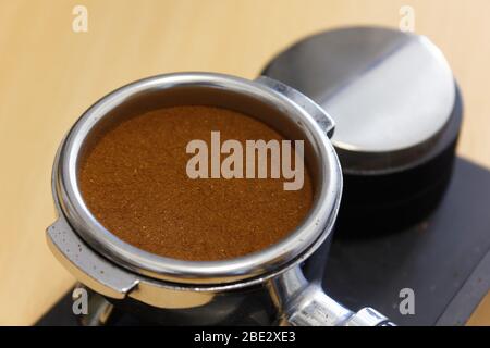 Caffè macinato macinato in portafiltro e livellatore Foto Stock