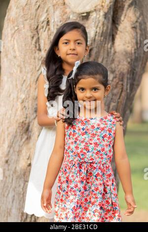 Piccole sorelle teneri che si abbracciano e mostrano il loro vero amore Foto Stock