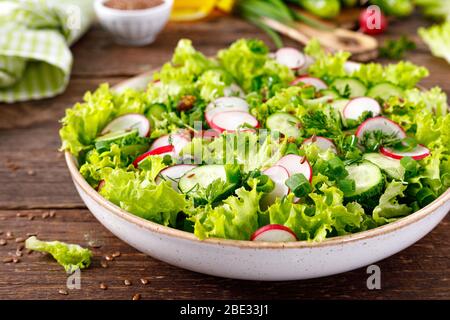 Insalata di verdure fresche di ravanello, cetrioli, lattuga, aneto e cipolla verde, sano cibo vegetariano Foto Stock