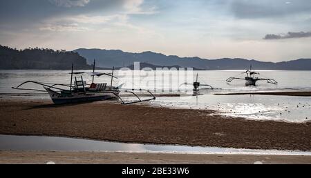 Barche a trefoli sulla spiaggia al tramonto Foto Stock