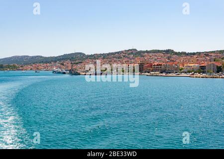 Vista sulla città di Argostoli a Cefalonia, Grecia dal traghetto che naviga verso Lixouri. Acqua percorso schiumoso dietro il traghetto Foto Stock