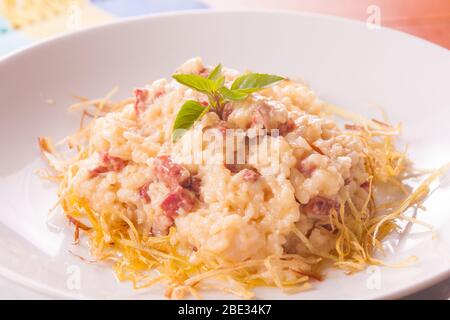 Formaggio e bacon Rissoto con fette di cipolla Foto Stock