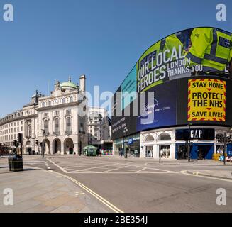 Messaggi del governo su schermo a LED a Piccadilly Circus vuoto e deserta durante il blocco forzato a causa di coronavirus covid 19 influenza pandemica Foto Stock