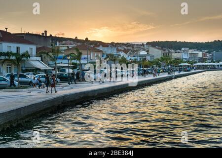 Vista panoramica del tramonto sulla città di Argostoli in Cefalonia Grecia. Persone che camminano lungo l'argine Foto Stock