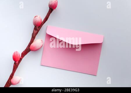 vista ad angolo elevato della busta rosa su bianco Foto Stock