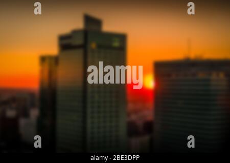 Tramonto sullo sfondo dei grattacieli. Paesaggio serale della grande città. Sfondo sfocato in colori caldi Foto Stock