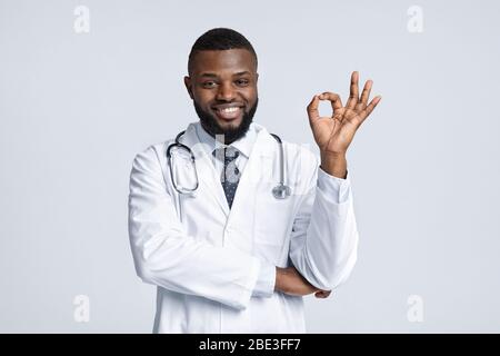 Terapista africano che raccomanda la sua clinica su sfondo bianco Foto Stock