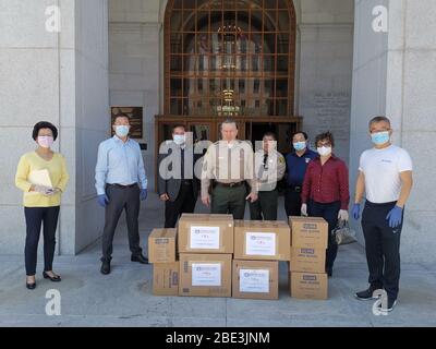 (200411) -- LOS ANGELES, 11 aprile 2020 (Xinhua) -- rappresentanti della Federazione Cinese Americano (CAF) posa per una foto con Los Angeles County Sheriff Alex Villanueva (C) come essi consegnare donazioni al reparto sceriffo nella Contea di Los Angeles, gli Stati Uniti, il 1 aprile 2020. Mentre i casi del COVID-19 sono alle stelle nella California meridionale negli stati Uniti, gli americani cinesi che hanno visto la popolazione cinese subire difficoltà durante lo scoppio in Cina si stanno intensificando per aiutare i loro vicini americani. PER ANDARE CON 'Scotlight: Gli Americani cinesi della California del sud donano i rifornimenti molto-necessari a. Foto Stock