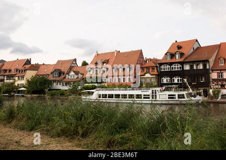 Un giro in barca e una serie di case lungo il fiume Regnitz a Bamberg, nell'alta Franconia, in Baviera, Germania. Foto Stock