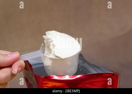 Polvere proteica in una tazza graduata Foto Stock