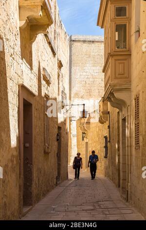 Due persone che camminano attraverso la Città silenziosa di Mdina, Malta Foto Stock