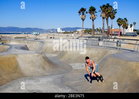 Uno skateboarder che esegue trucchi allo Skatepark di Venice Beach, Santa Monica, California. Foto Stock